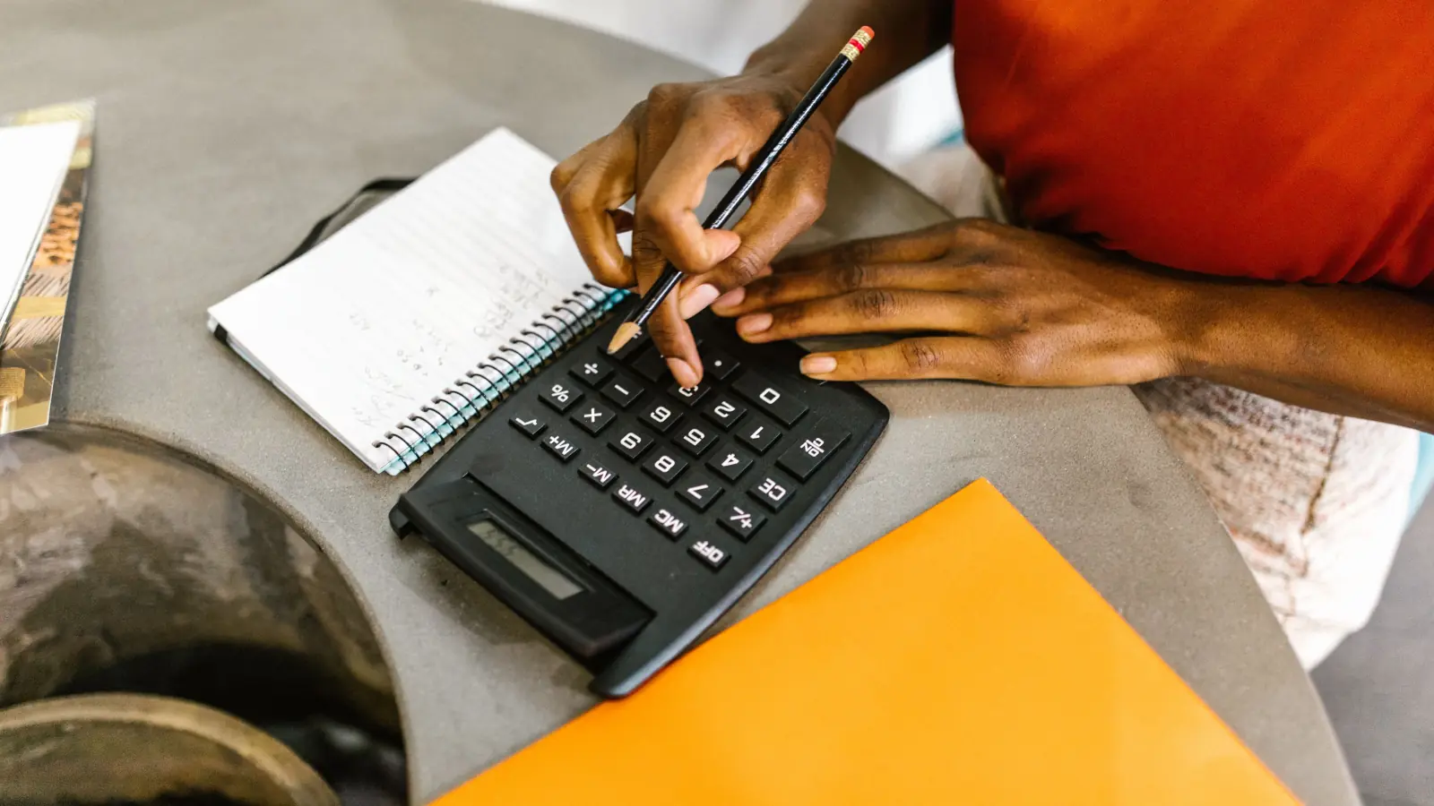 Working out a figure on a calculator beside a notepad